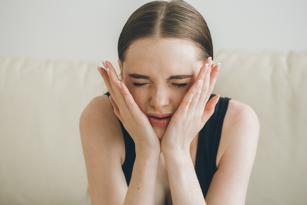 girl holding jaw in pain